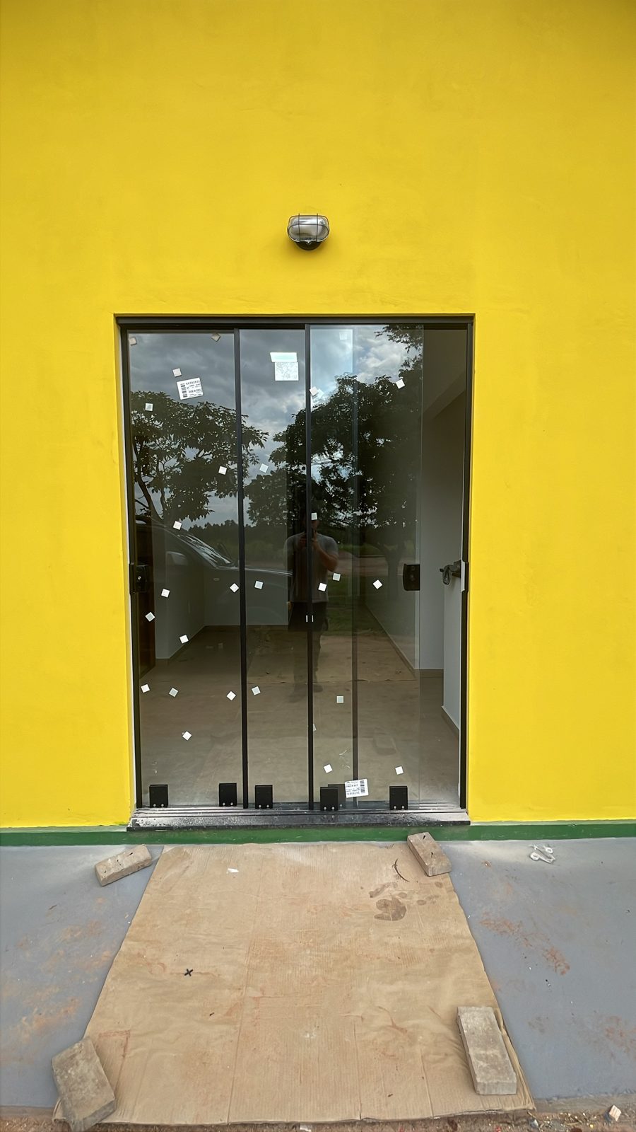 Porta de vidro de correr em parede amarela